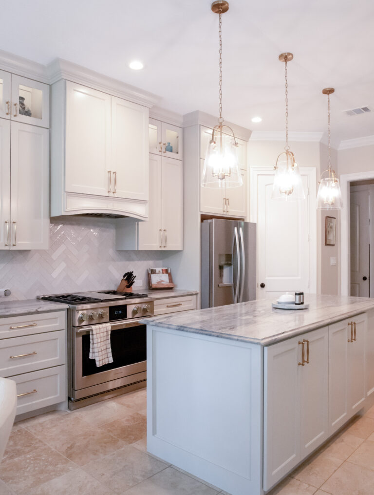 Bright white kitchen with pendent lights and marble countertops